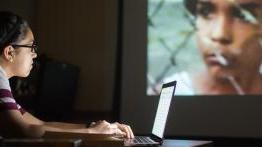 学生梅根·梅德拉诺在分析电影时使用她的笔记本电脑