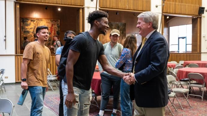 Enron Whistleblower Jim Timmins shakes hand with a student in the Chapman Great Hall